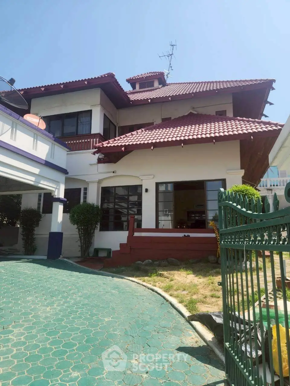 Charming two-story house with red roof and spacious driveway