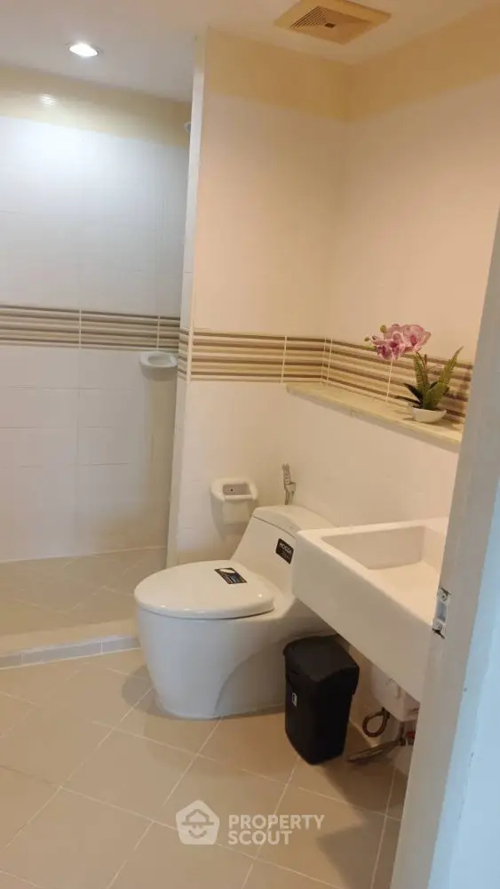 Modern bathroom with sleek white fixtures and stylish tile accents