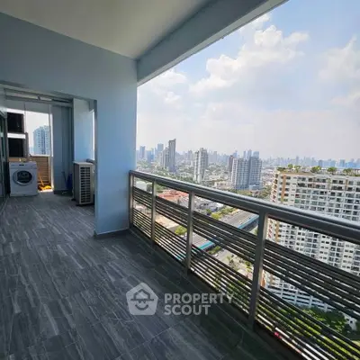 Spacious balcony with stunning city skyline view in modern high-rise apartment.