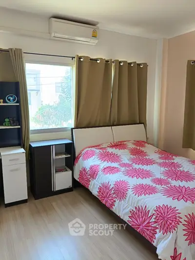 Cozy bedroom with floral bedding and ample natural light