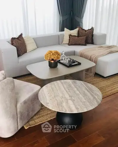 Elegant living room with modern furniture and cozy decor, featuring a stylish coffee table and plush seating.
