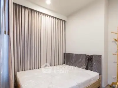 Cozy bedroom with natural light and elegant curtains, perfect for relaxation.