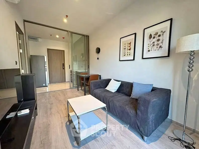Modern living room with stylish decor and open layout, featuring a cozy sofa and elegant lighting.