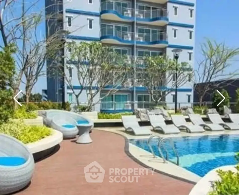 Luxurious apartment building with poolside relaxation area and modern amenities.