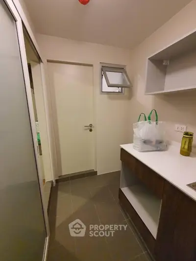 Compact storage room with modern cabinetry and tiled flooring