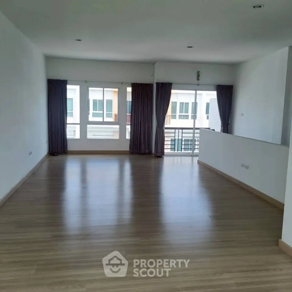 Spacious living room with large windows and balcony access in modern apartment.