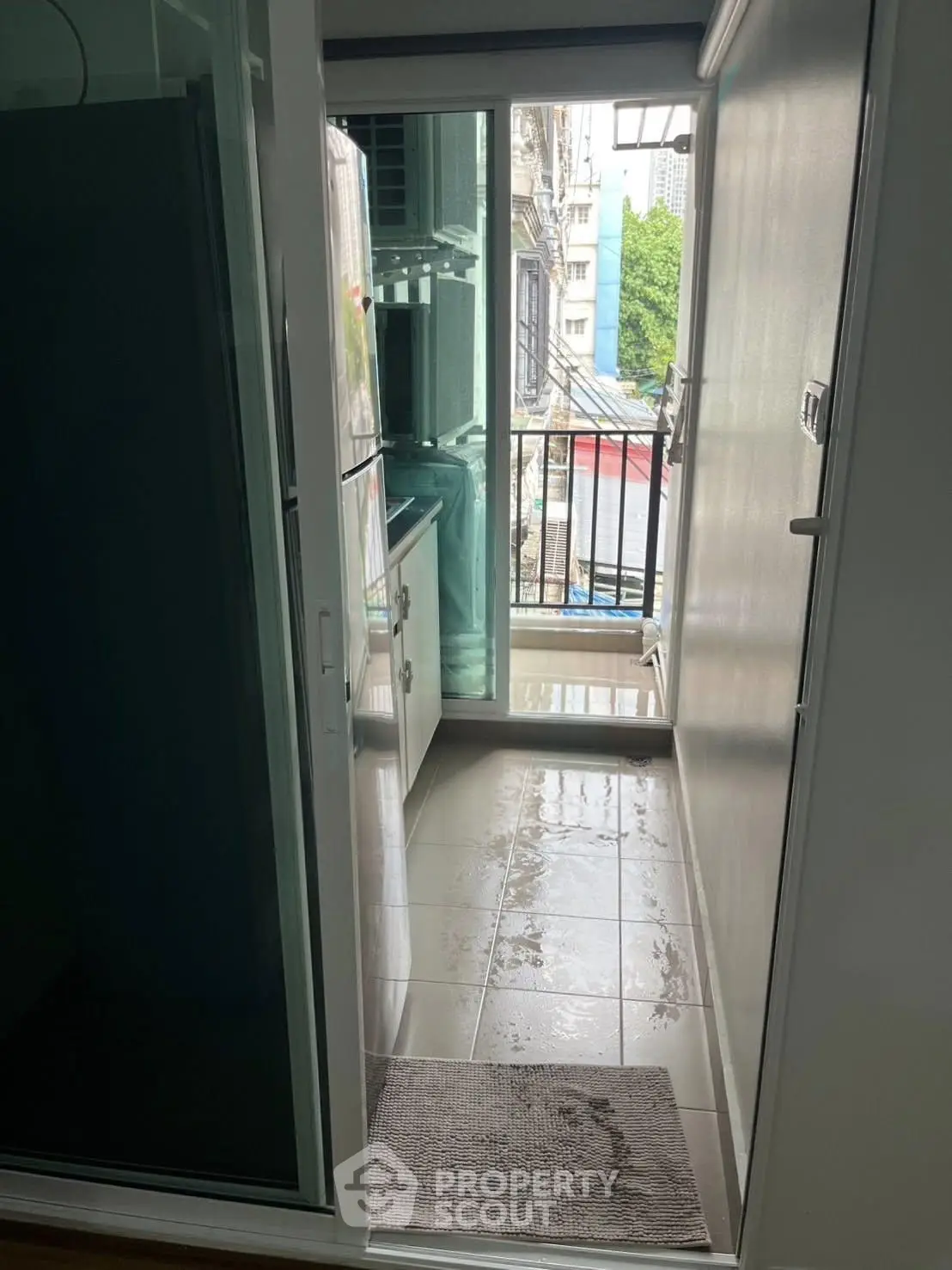 Compact balcony with glass doors and city view, ideal for urban living.