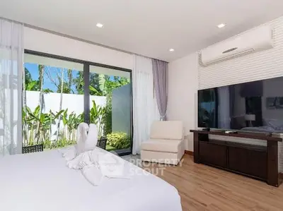Luxurious bedroom with large TV and garden view, perfect for relaxation and comfort.