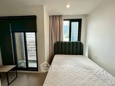 Modern bedroom with large window and stylish headboard in urban apartment