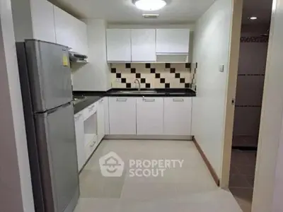 Modern kitchen with sleek cabinetry and stylish backsplash in a contemporary apartment.
