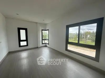 Spacious empty room with large windows offering abundant natural light and scenic views.