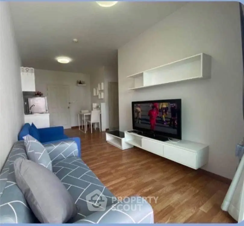 Modern living room with stylish furniture and wall-mounted TV, perfect for relaxation and entertainment.