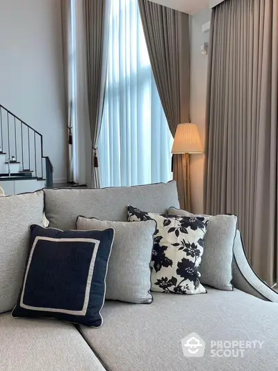 Elegant living room with stylish sofa and floor-to-ceiling curtains