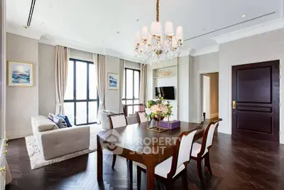 Luxurious living room with elegant chandelier and large windows in a modern apartment.