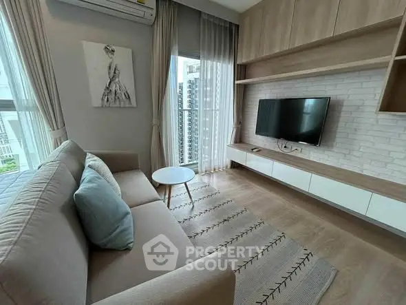 Modern living room with stylish decor, featuring a cozy sofa, wall-mounted TV, and large windows with city view.