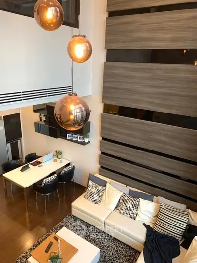 Stunning modern living room with high ceilings and elegant lighting fixtures.
