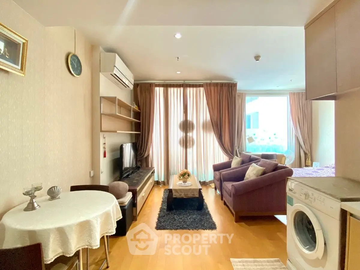 Cozy living room with modern decor and washing machine in open layout apartment.