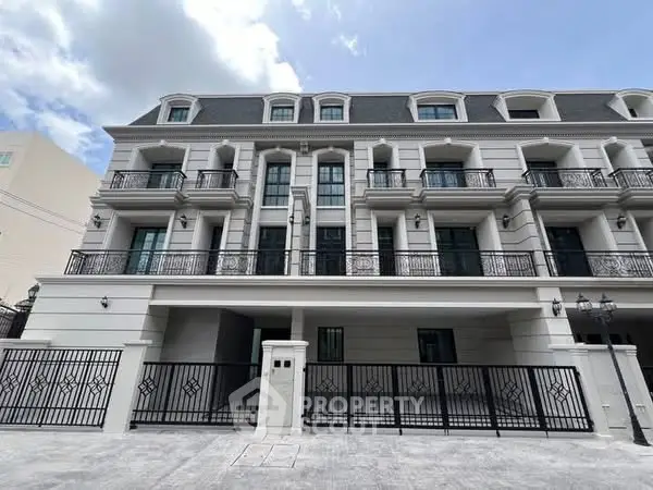 Elegant multi-story building with classic architecture and gated entrance.
