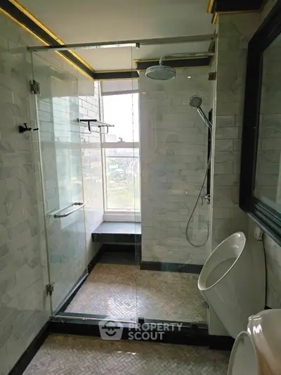 Luxurious bathroom with glass shower and city view window