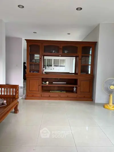 Spacious living room with elegant wooden furniture and tiled flooring