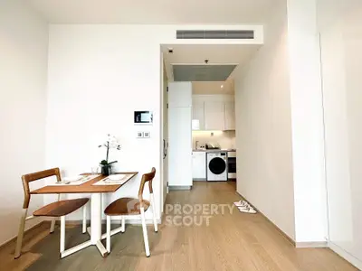 Modern open-plan kitchen and dining area with sleek appliances and wooden flooring.