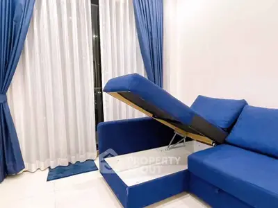 Modern living room with blue sofa and elegant curtains, featuring hidden storage space.