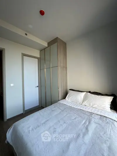 Modern bedroom with sleek wardrobe and cozy bed in a minimalist design.