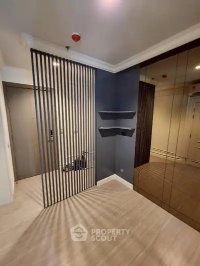 Modern apartment entrance with sleek design and mirrored closet