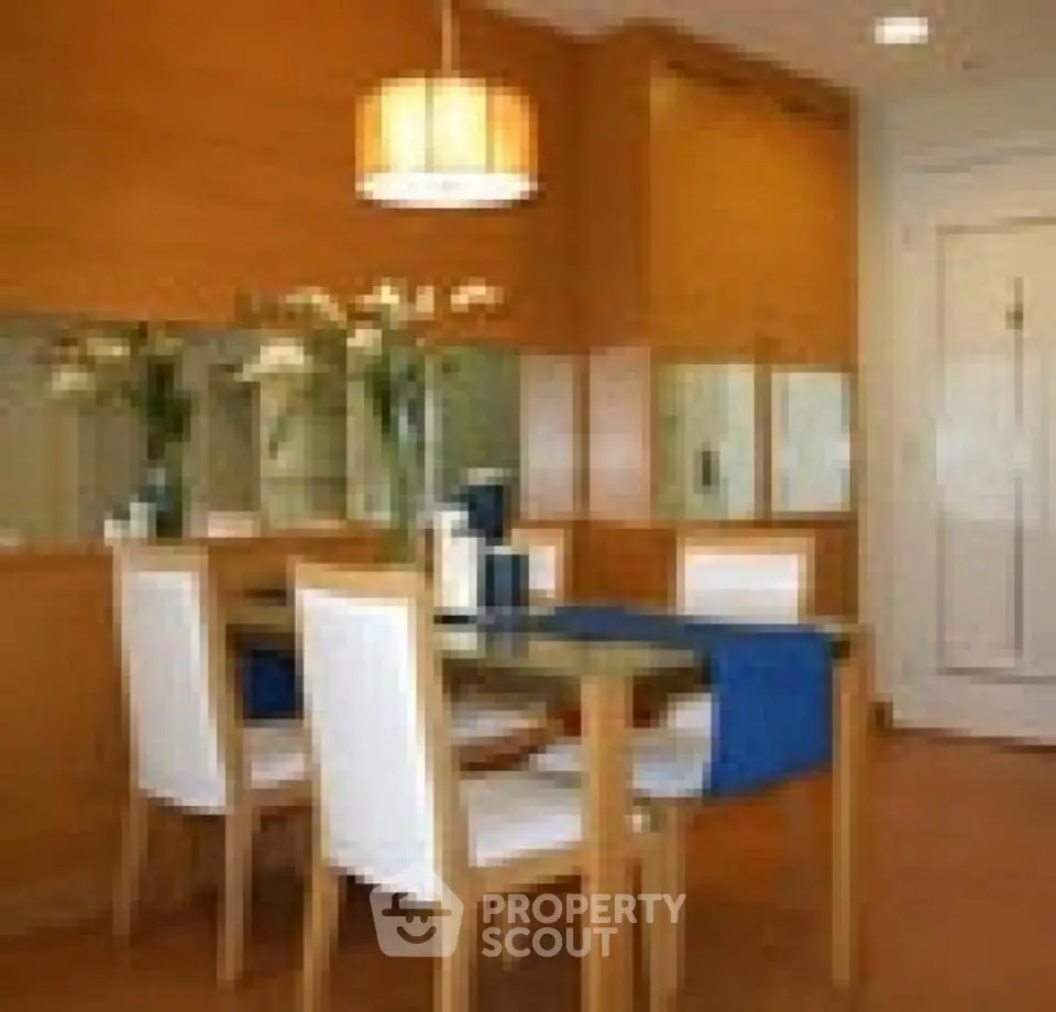 Elegant dining area with wooden accents and modern lighting in a cozy apartment.