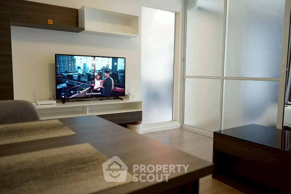 Modern living room with sleek furniture and TV, featuring a cozy ambiance.