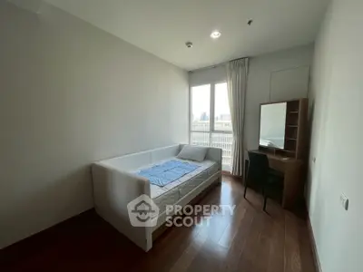 Modern bedroom with city view, featuring a sleek bed and study desk, perfect for urban living.