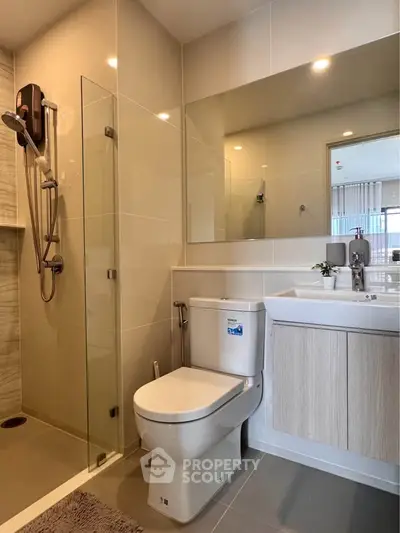 Modern bathroom with sleek fixtures and glass shower enclosure in a contemporary apartment.