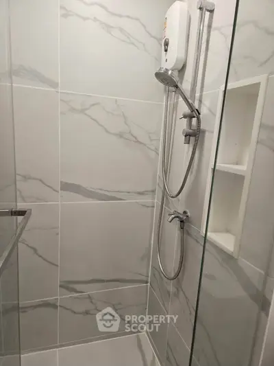 Modern bathroom with sleek marble tiles and glass shower enclosure