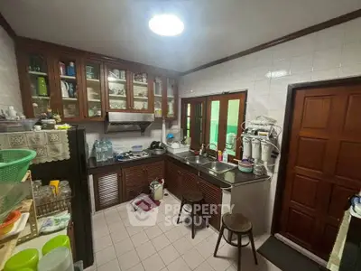 Charming kitchen with wooden cabinets and tiled backsplash, featuring a cozy and functional layout.