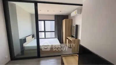 Modern bedroom with large window and minimalist furniture in high-rise apartment