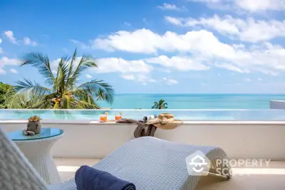 Luxurious beachfront balcony with stunning ocean view and modern lounge chairs