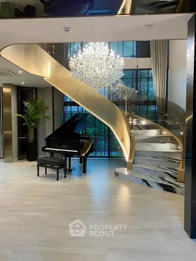 Luxurious living room with grand piano and elegant spiral staircase under a stunning chandelier.