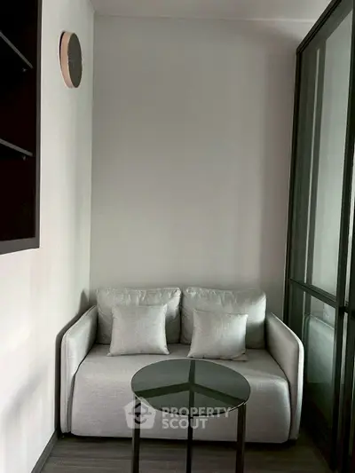 Cozy small living room with modern sofa and glass table