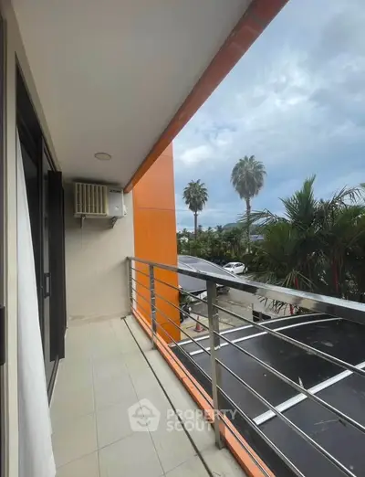 Modern balcony with sleek railing and palm tree view, perfect for relaxation.