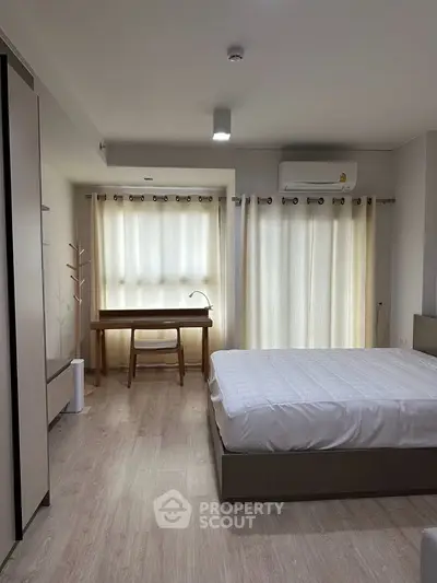 Modern bedroom with natural light, featuring a cozy bed, study desk, and stylish decor.