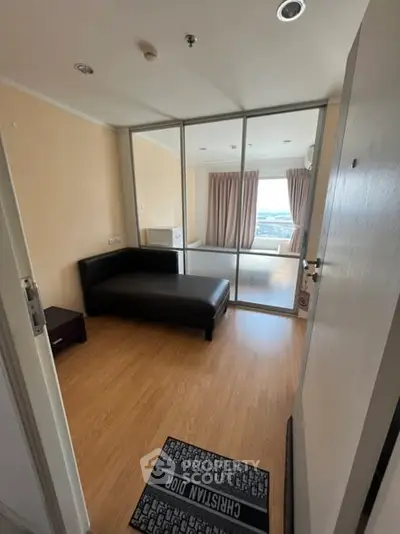 Modern bedroom with wooden flooring and glass partition, offering a cozy and stylish living space.