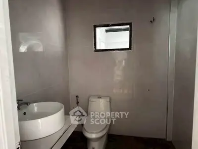 Compact bathroom with modern fixtures and minimalist design.