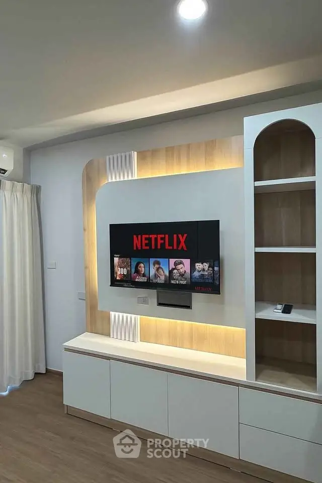Modern living room with built-in TV unit and ambient lighting, perfect for entertainment.