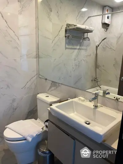 Modern bathroom with marble tiles and sleek fixtures in a contemporary apartment.