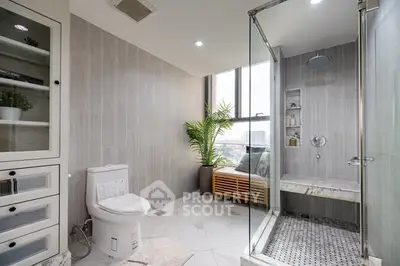 Spacious modern bathroom with glass shower and city view window.