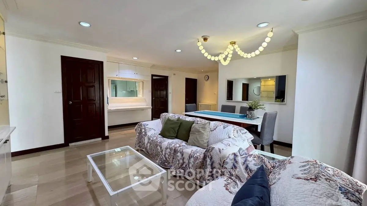 Spacious living room with elegant chandelier and modern decor in a stylish apartment