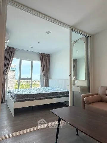 Modern bedroom with large window and city view, featuring cozy furnishings and sleek design.