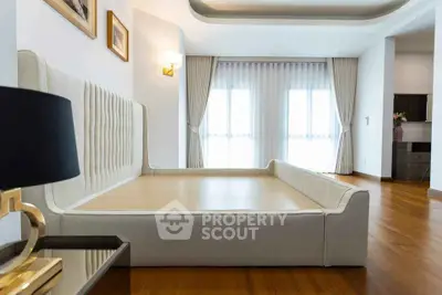 Spacious modern bedroom with elegant decor and large windows for natural light.