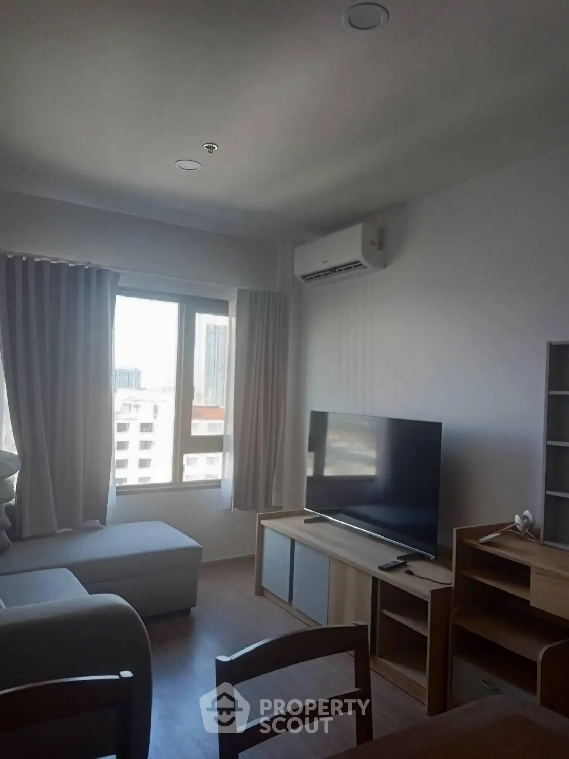 Modern living room with large window and air conditioning in urban apartment