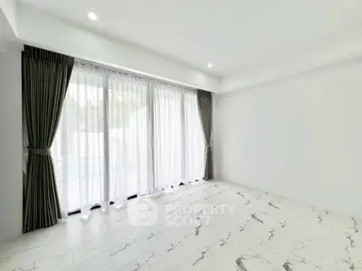 Spacious and bright living room with elegant marble flooring and large windows for natural light.